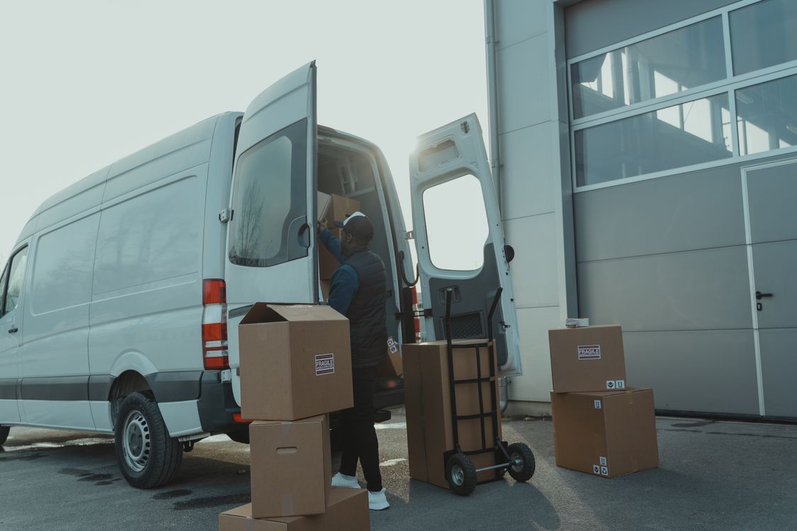 Courier loading customer parcels into a delivery van